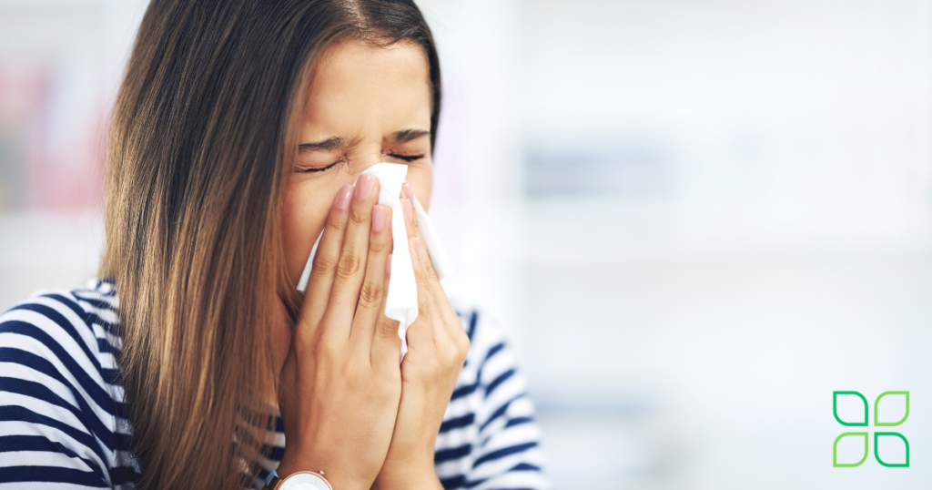 a woman blowing her nose because of allergies