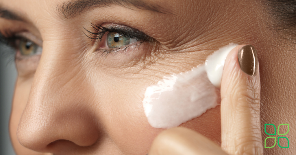 a close up of a woman putting anti aging cream around the corner of her eye