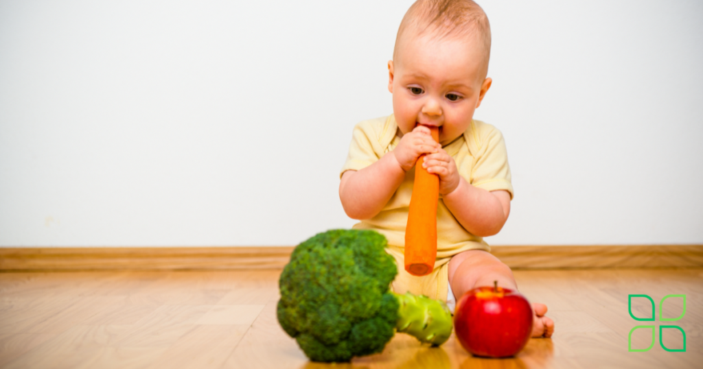 baby chewing on bright colored vegetables for carotenoids