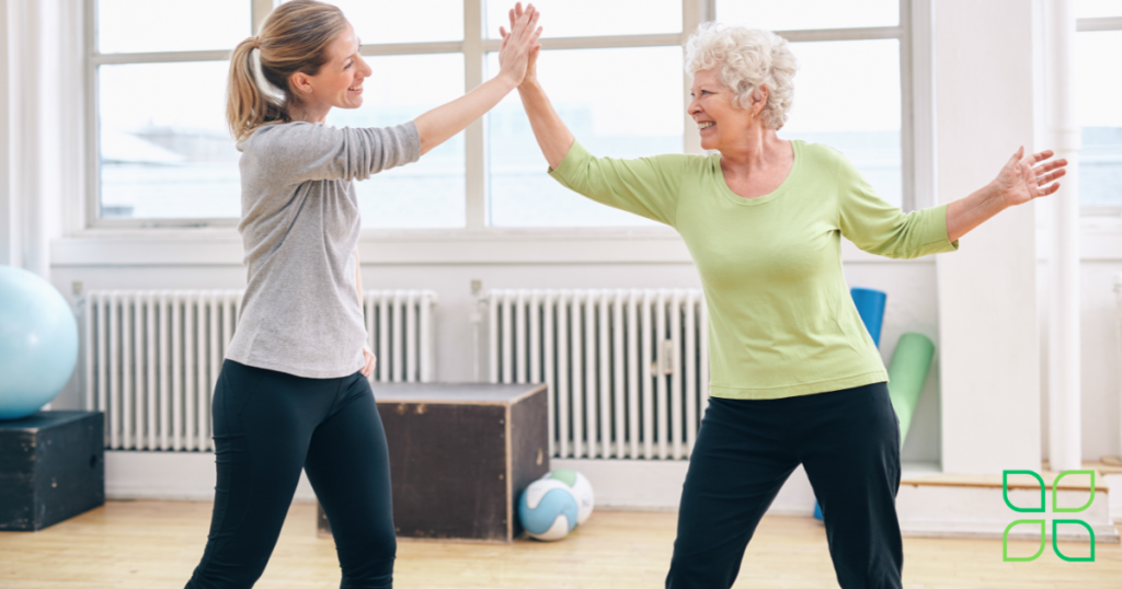 elderly woman pain free high fiving physical therapist